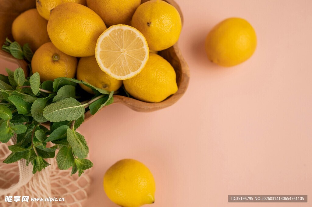 粉色背景中的柠檬与绿叶