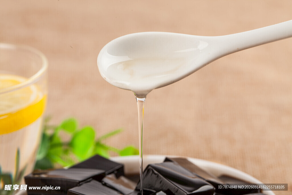 勺子舀酸奶浇在龟苓膏上