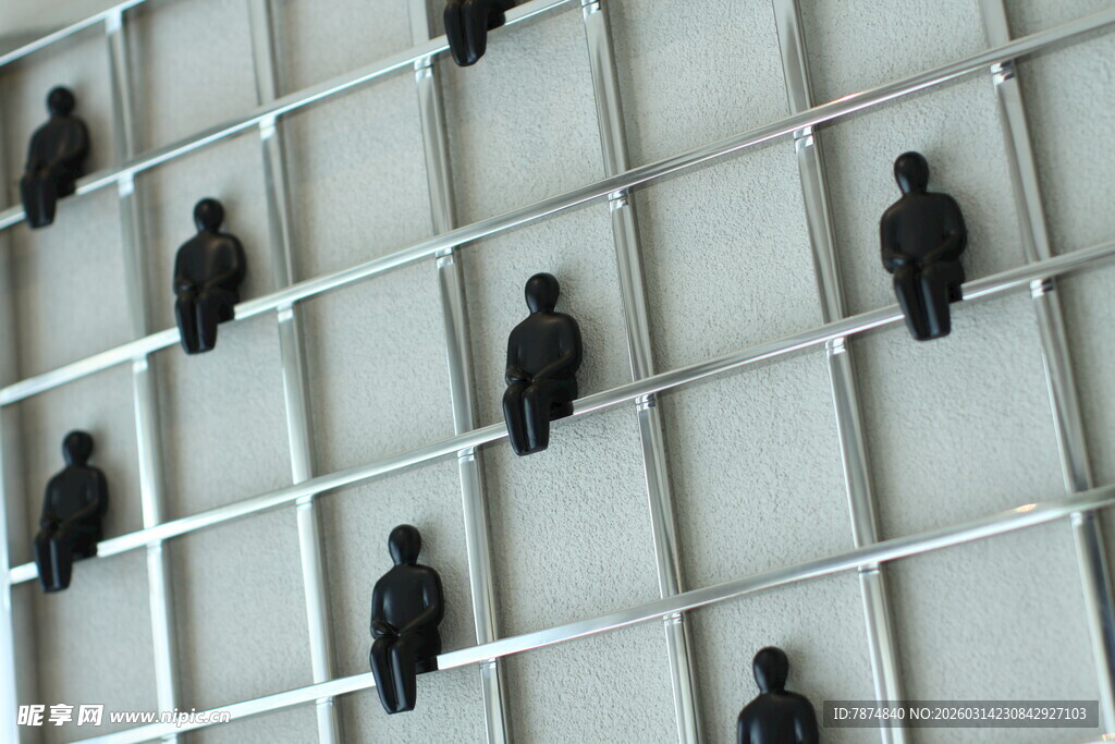 墙面站立的黑色小人雕塑