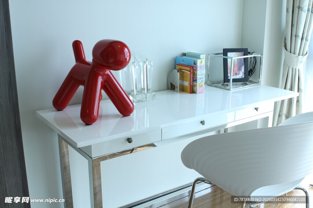 白色书桌旁的红色小狗摆件