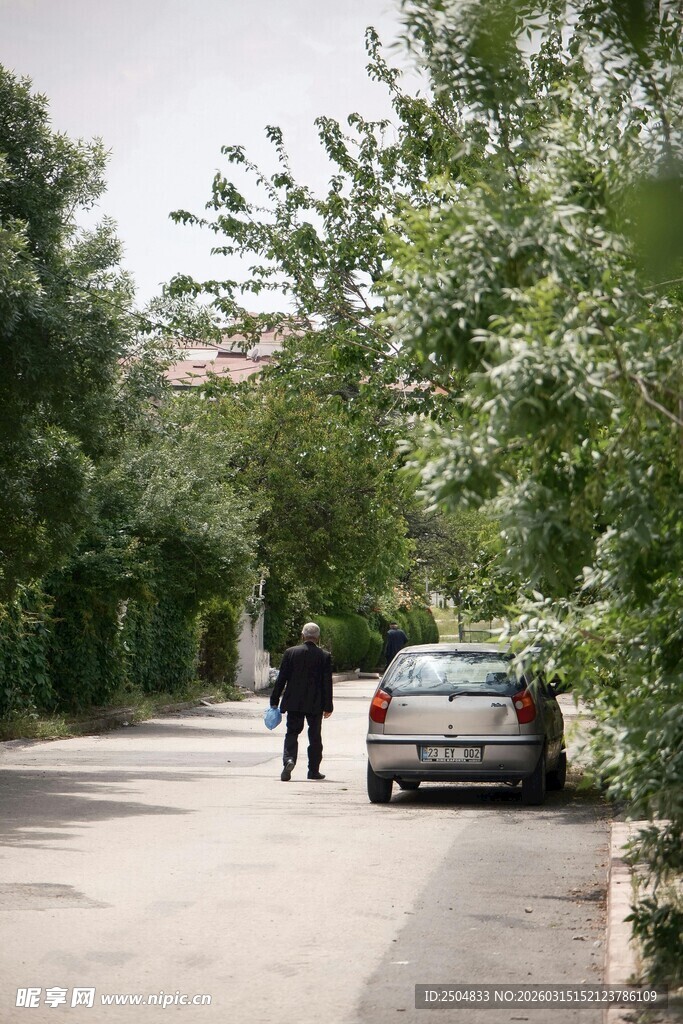 道路旁两人与停放的汽车