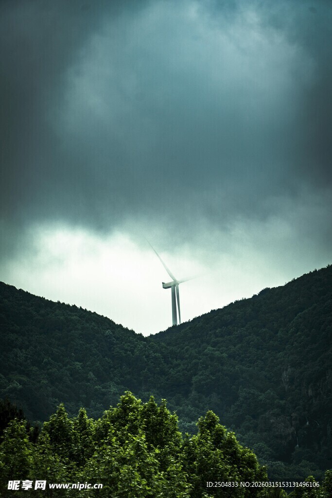 山峦间云雾下的高耸风车
