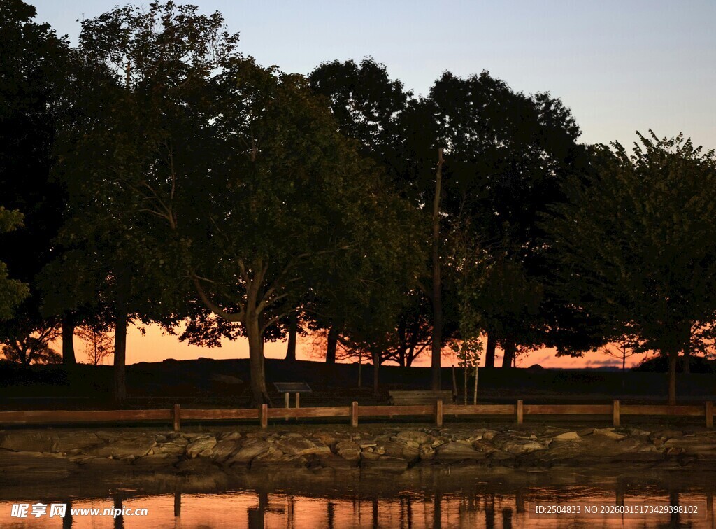 夕阳下湖畔树木倒影美景