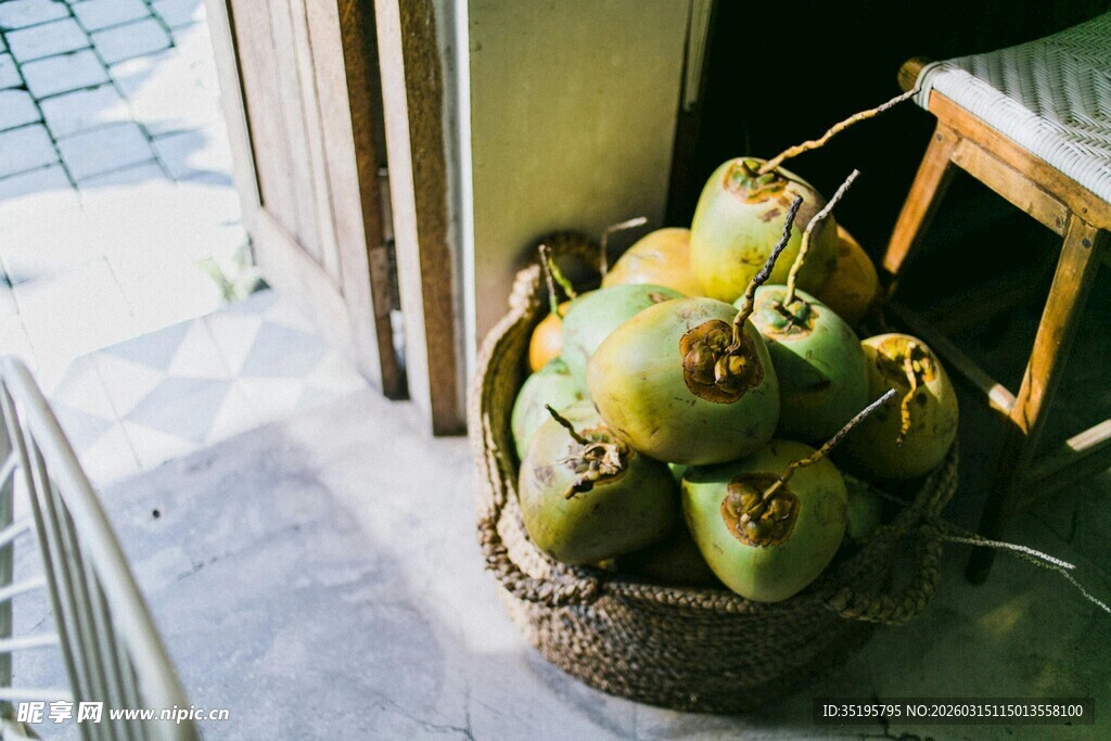窗边筐中堆放的新鲜椰子