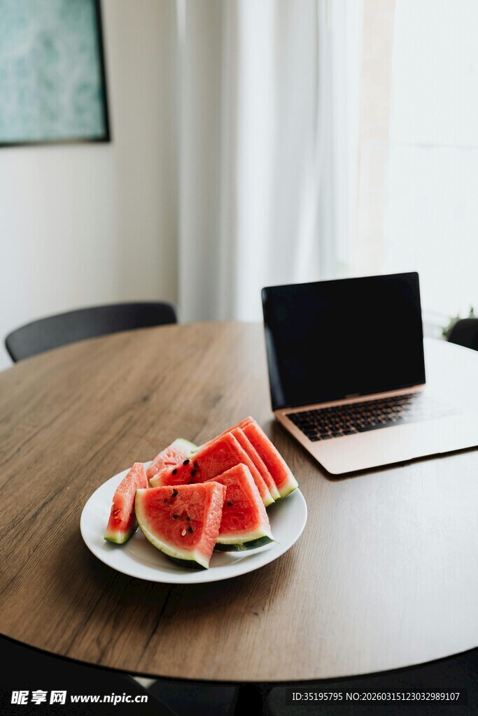 桌上西瓜与笔记本电脑