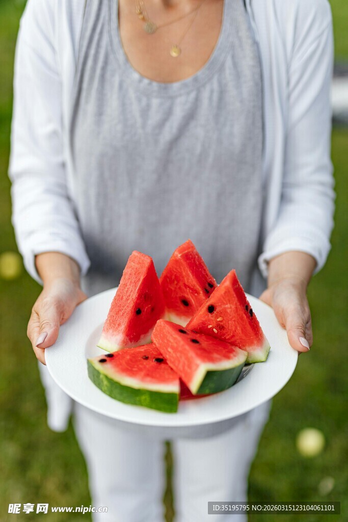 女士手持盘中西瓜