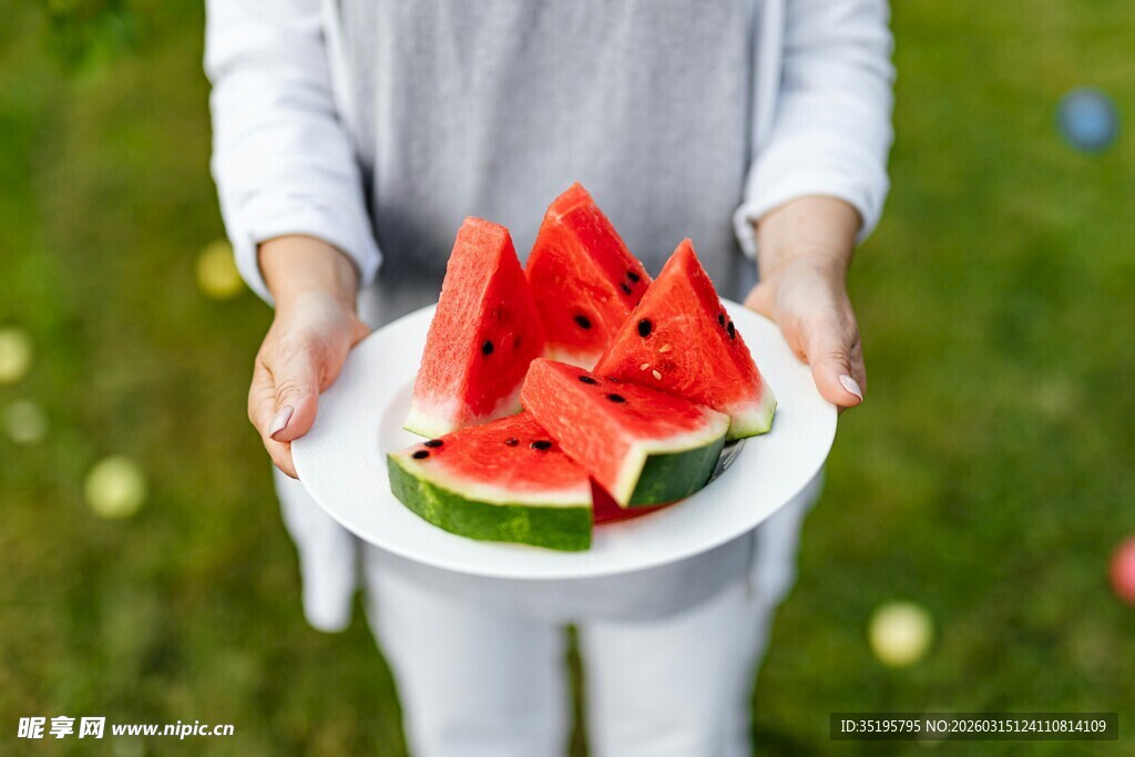 双手捧盘的新鲜切块西瓜