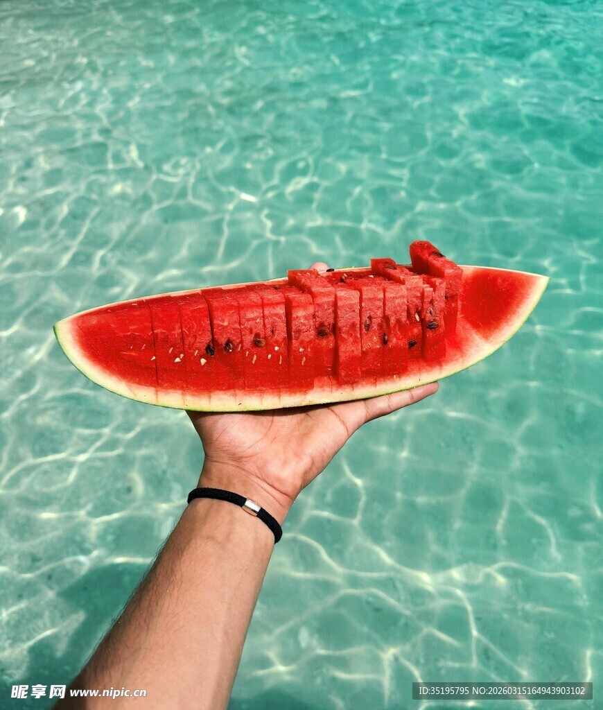 手托西瓜于清澈海水之上