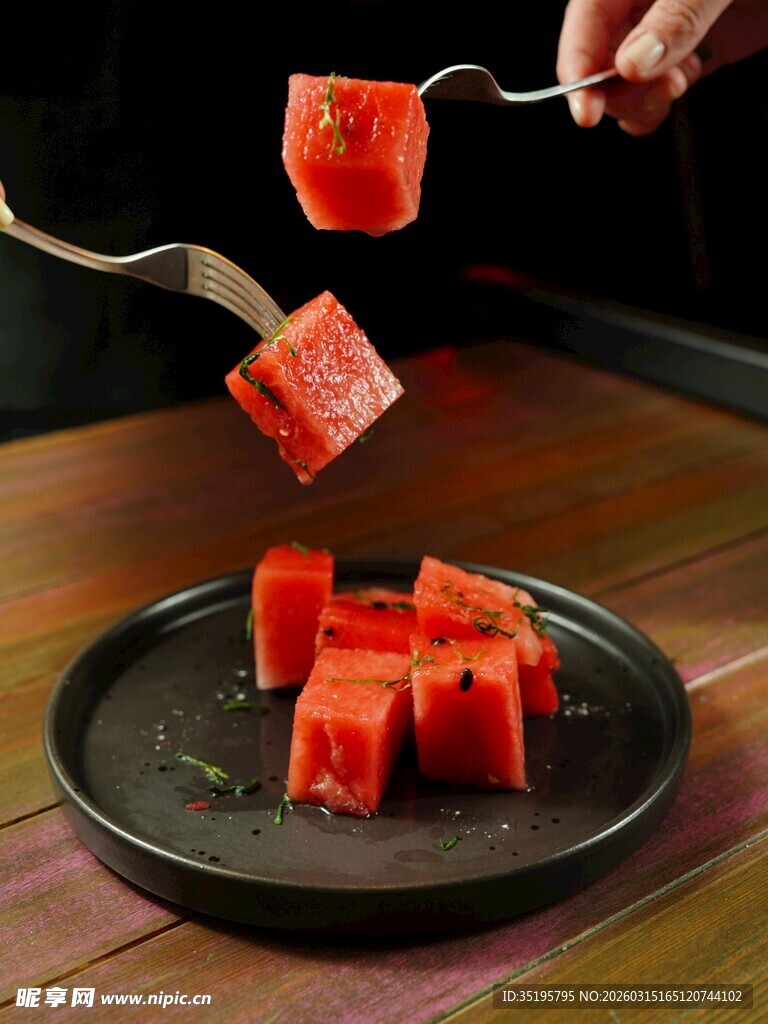 叉子叉起的新鲜西瓜块