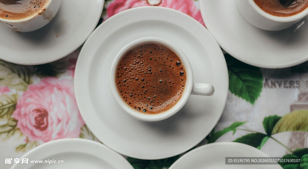 精致咖啡摆放在花卉桌布上