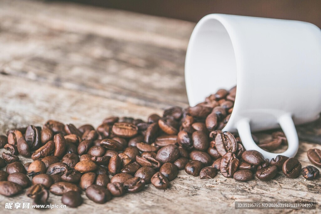 洒落的咖啡豆与白色杯子