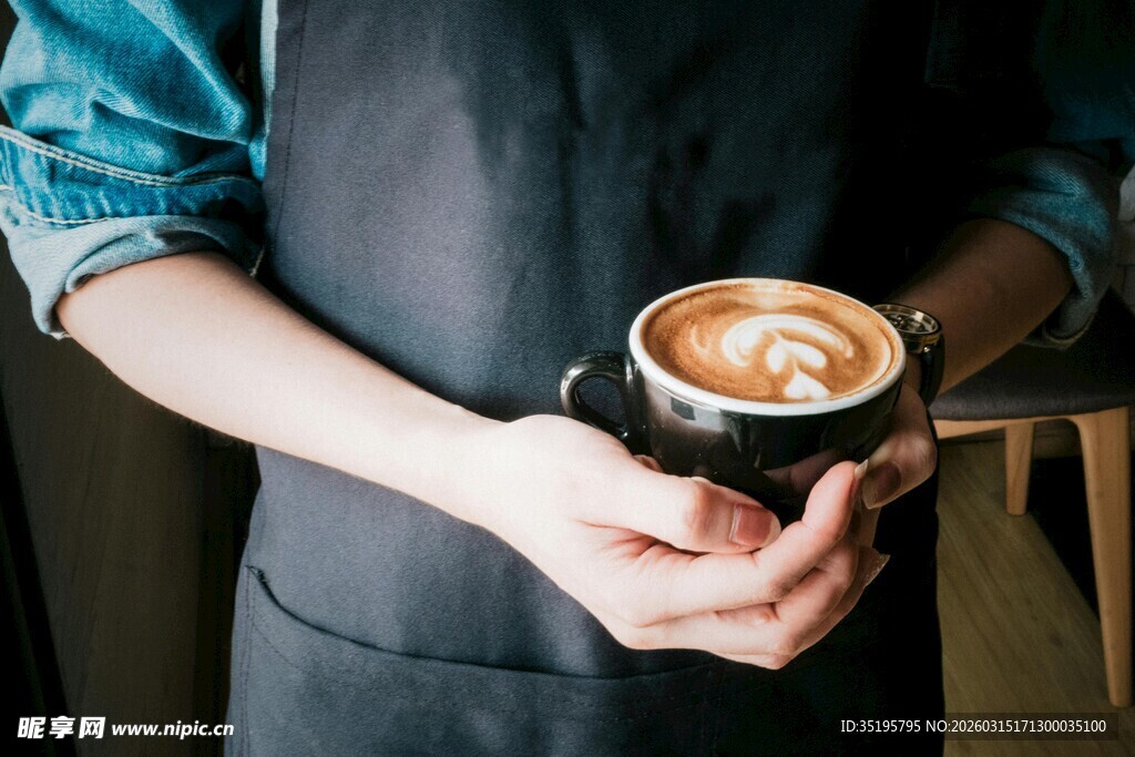 双手捧起精美拉花咖啡