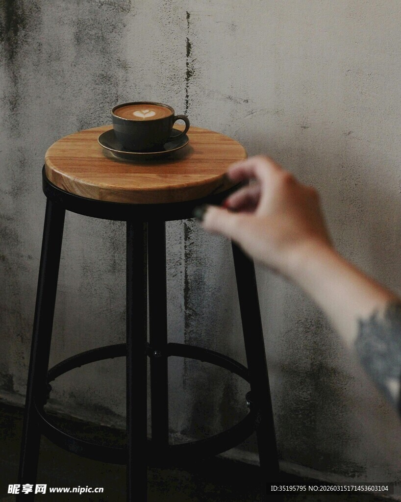 手触木凳上的咖啡杯