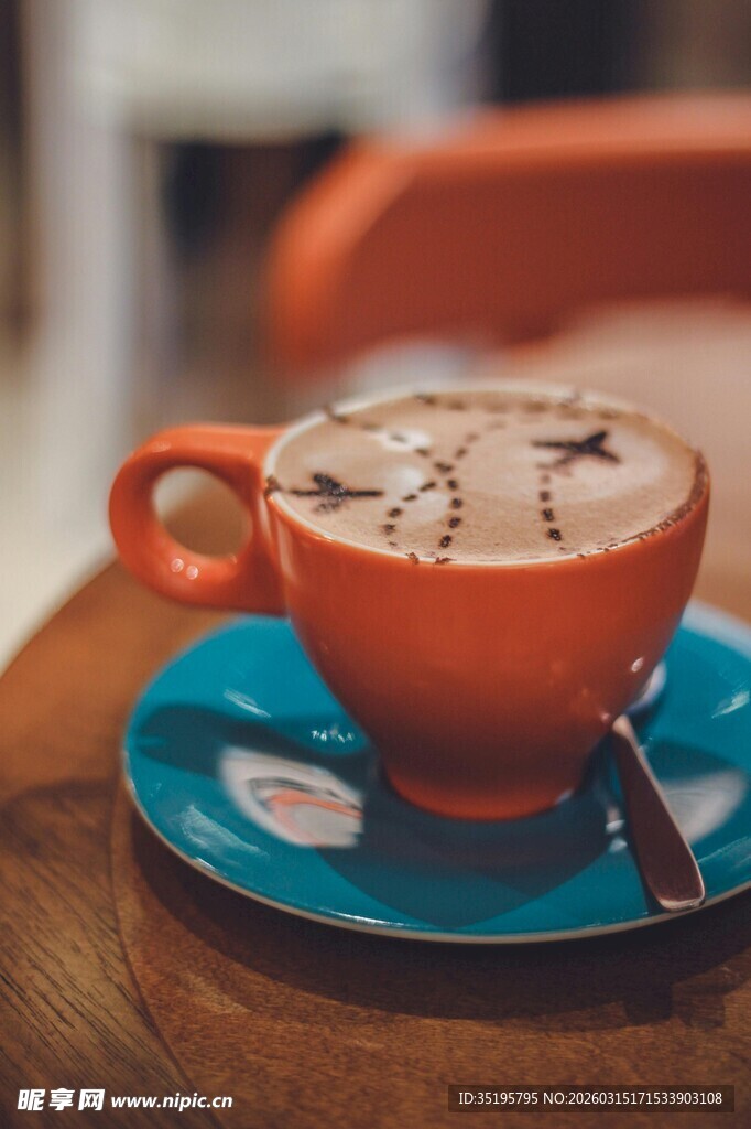 橙色杯中的精美拉花咖啡
