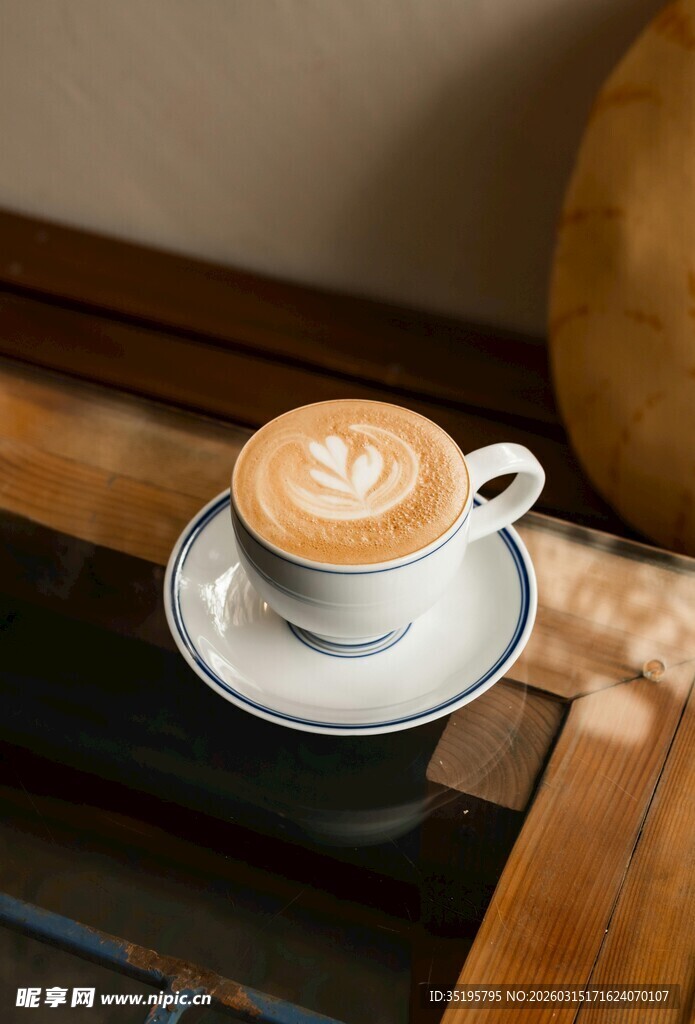 精致拉花咖啡置于木桌