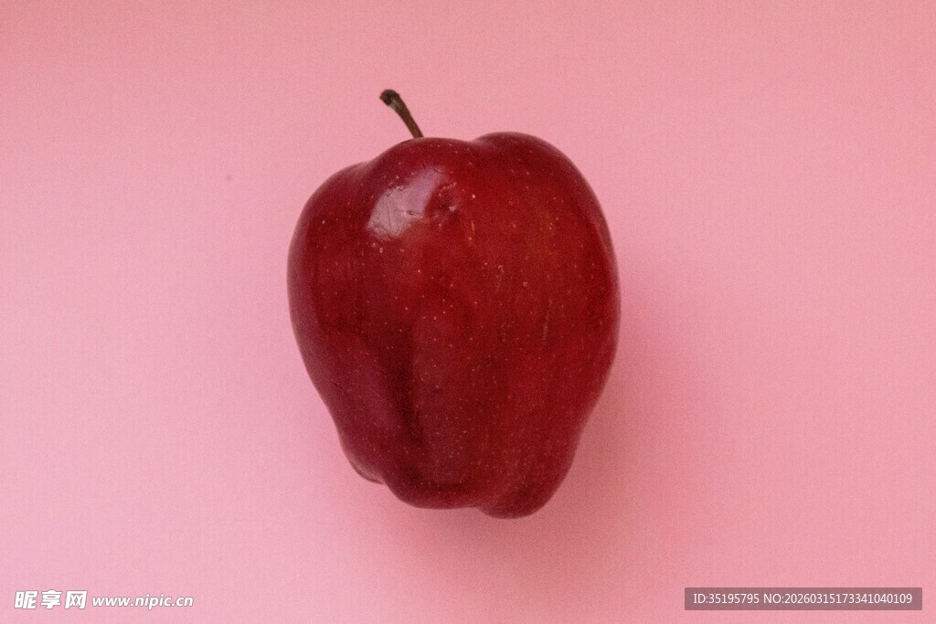 粉红背景上的红苹果