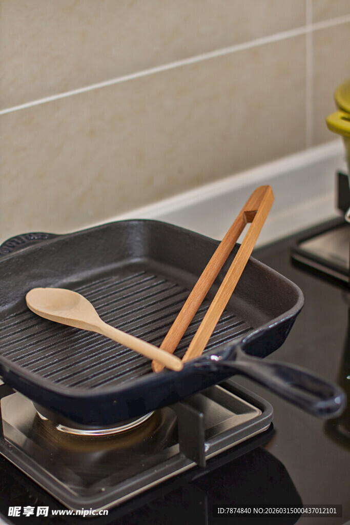 炉灶上的烹饪锅具与木铲