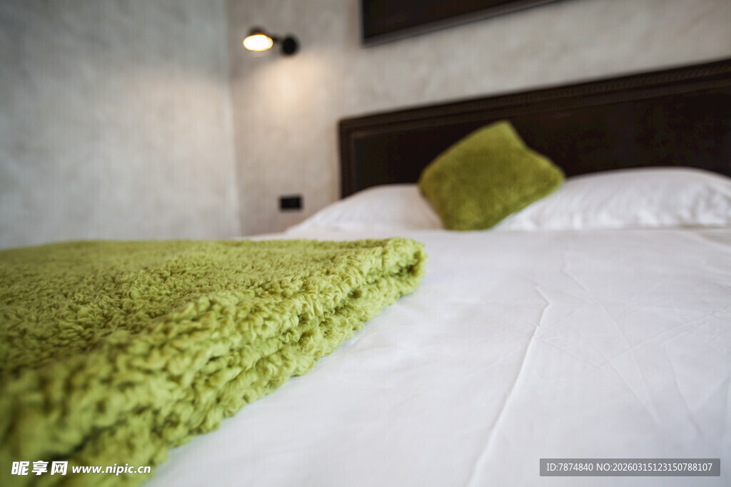 舒适卧室中的绿色毛毯与枕头