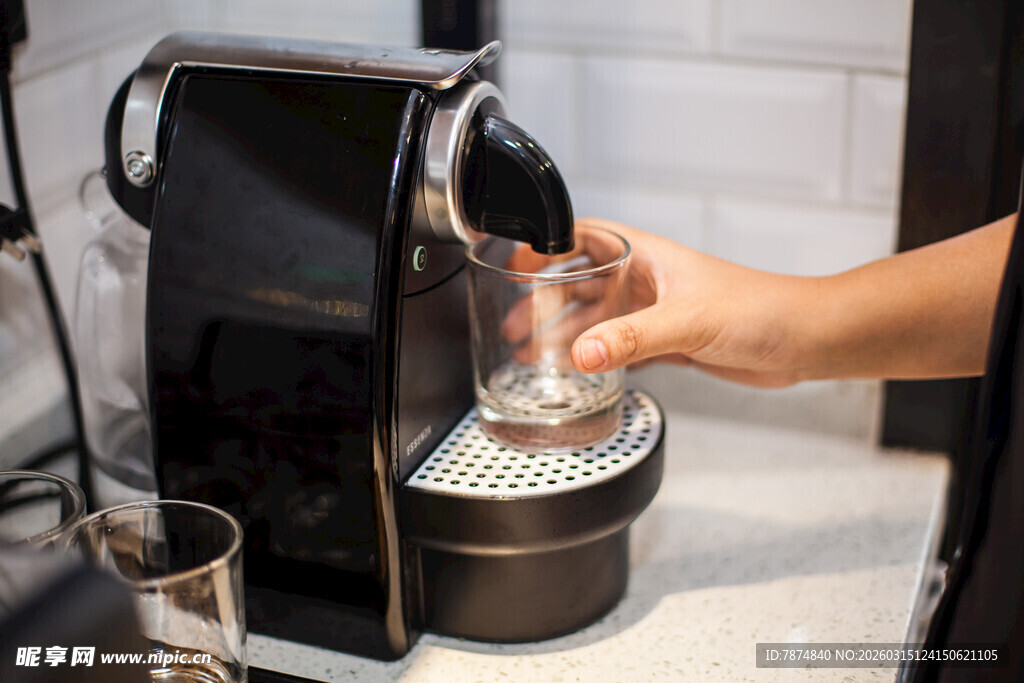 手捧杯接咖啡机流出咖啡