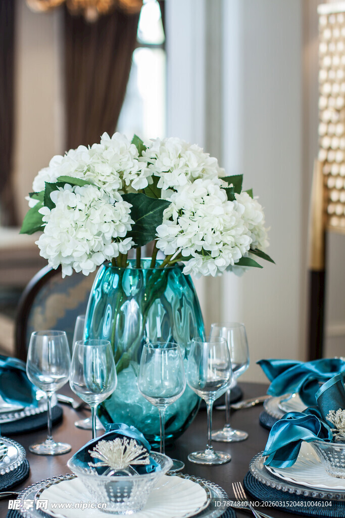 蓝绿花瓶配白花的餐桌布置