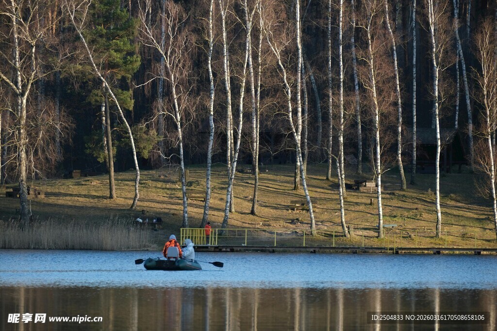 湖上泛舟赏岸边树林风光