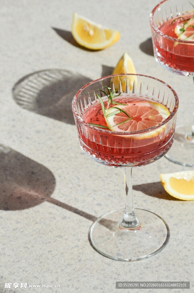 两杯红色鸡尾酒配柠檬片