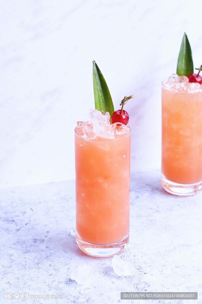 两杯鲜果装饰的橙色饮品