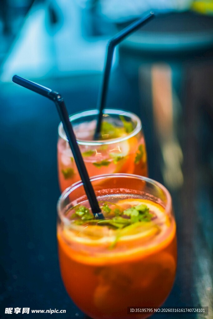 两杯橙色饮品配黑色吸管