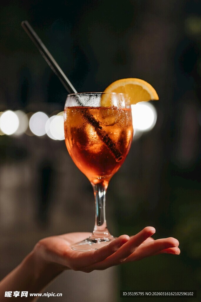 手持橙片装饰的夏日鸡尾酒
