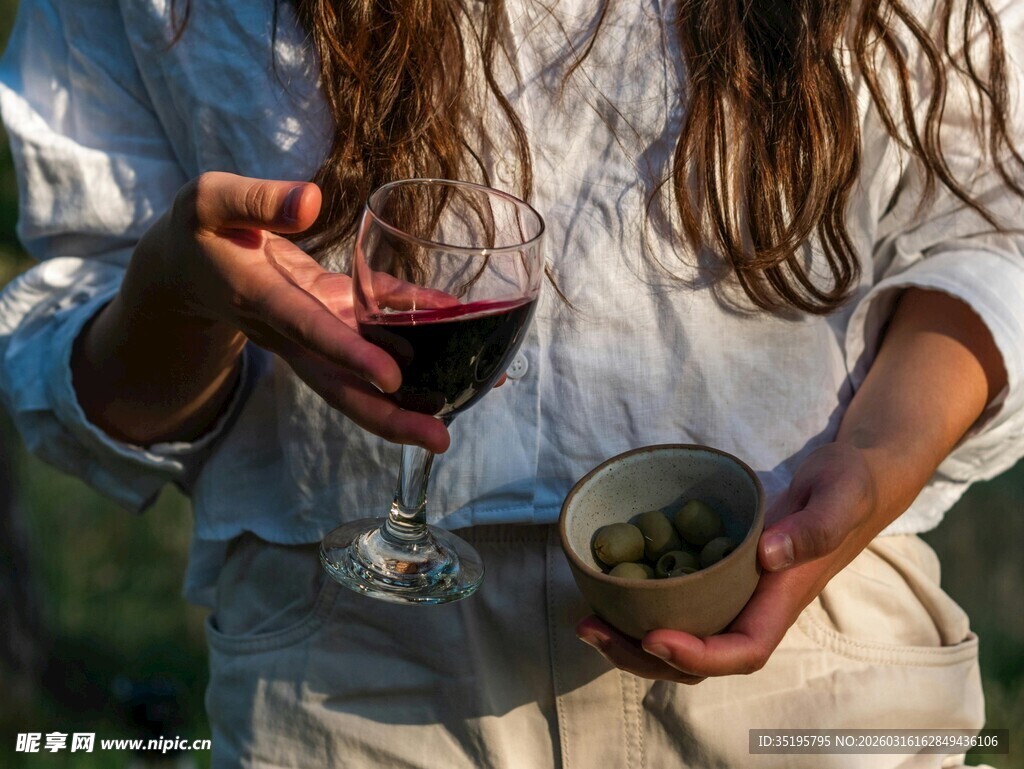 手持红酒与绿植的惬意瞬间