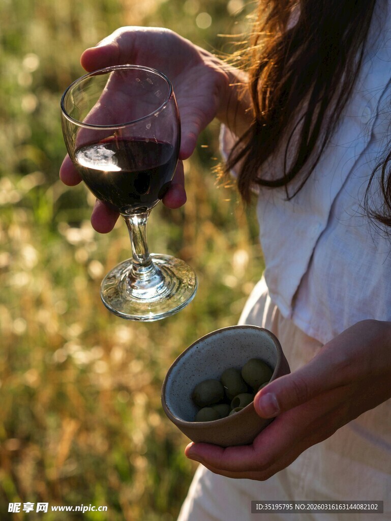 手持酒杯与橄榄的田园场景