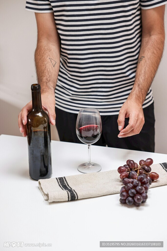 倒红酒的人及桌上葡萄等