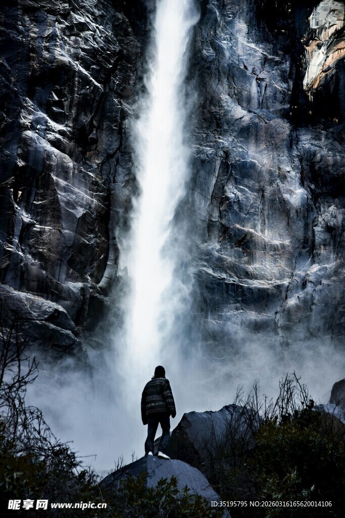 人于瀑布前独坐赏景