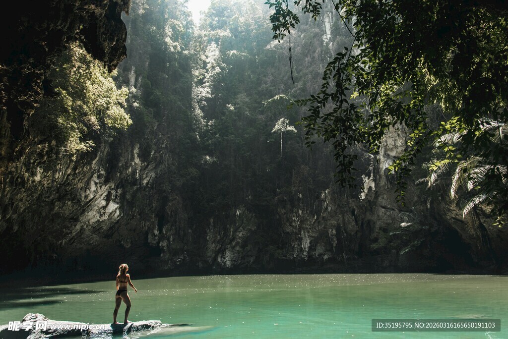 人于碧绿潭边泛舟赏景
