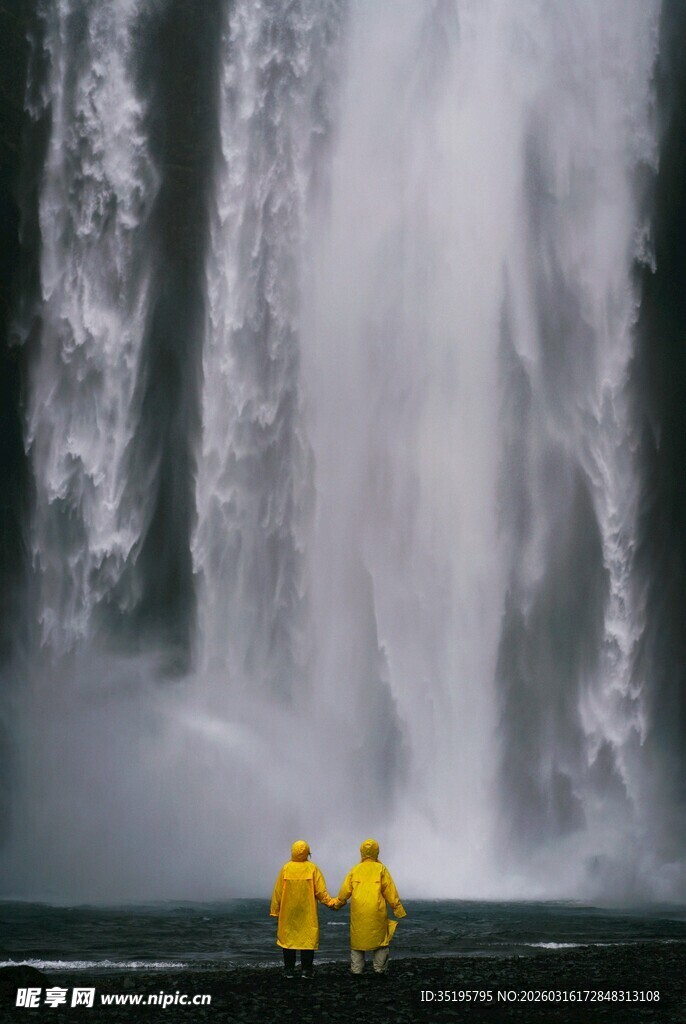 瀑布前的黄色雨衣身影