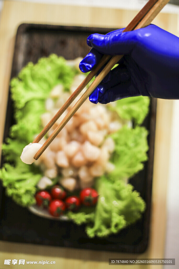 蓝手套持筷夹取虾仁美食