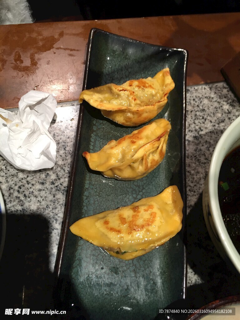 美味煎饺摆放在黑色盘上