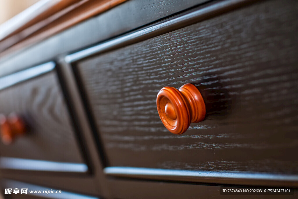 深色木柜上的橙色旋钮