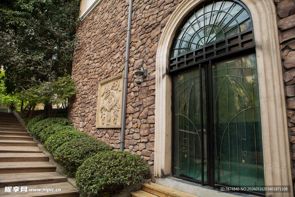 石砌建筑旁的绿植与玻璃门