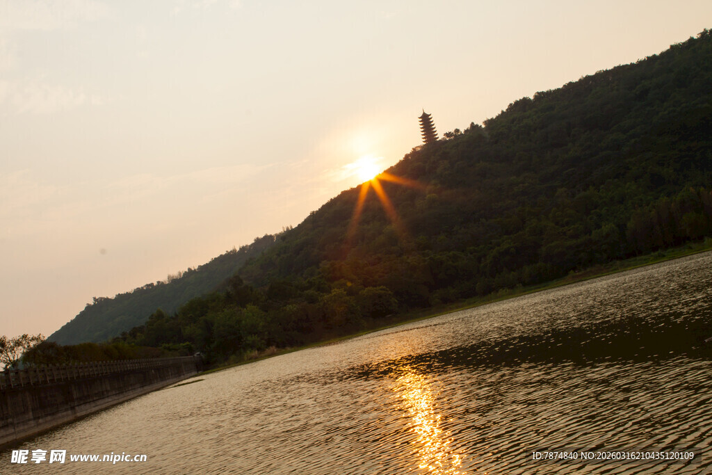夕阳下湖边山峦与宝塔