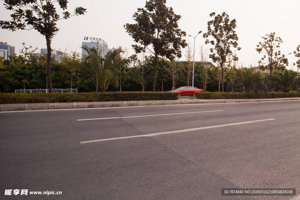空旷道路旁的绿树与车辆