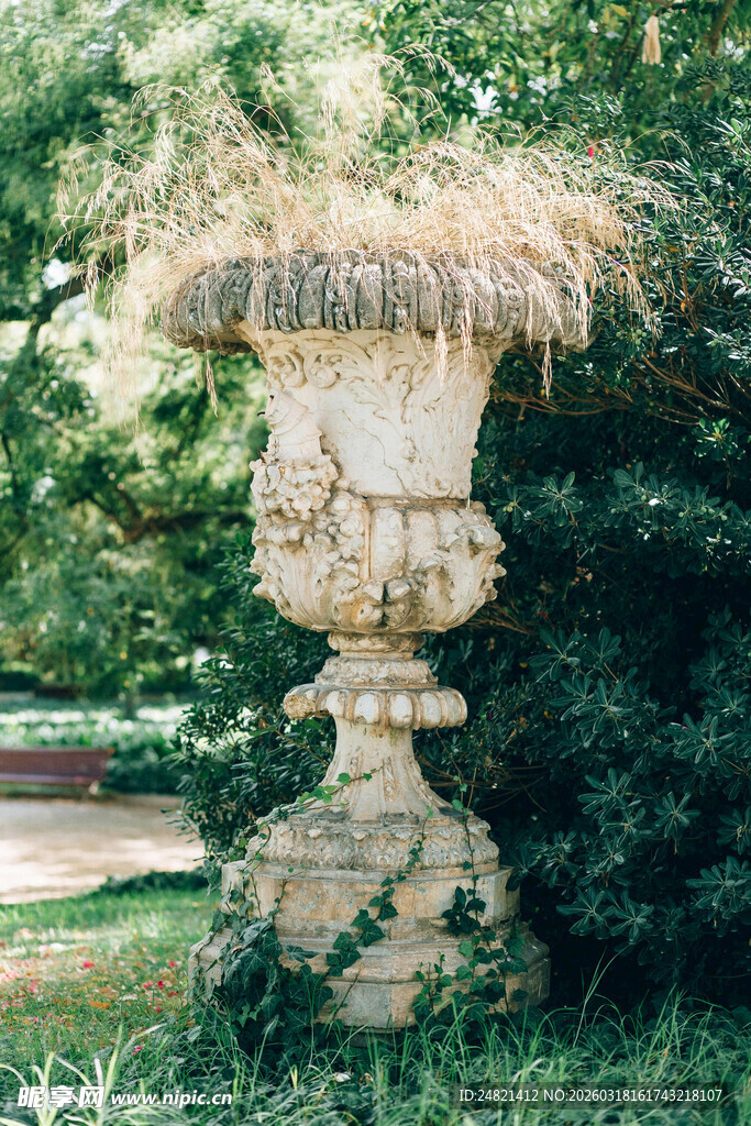 古典石制花盆立于绿植中