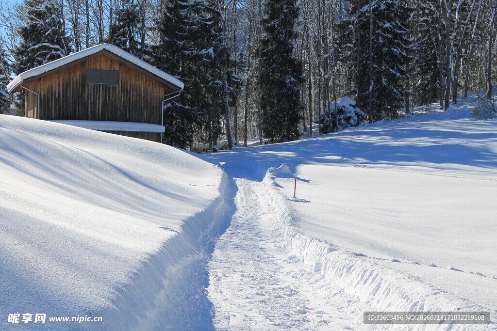 雪中小屋旁的蜿蜒雪道