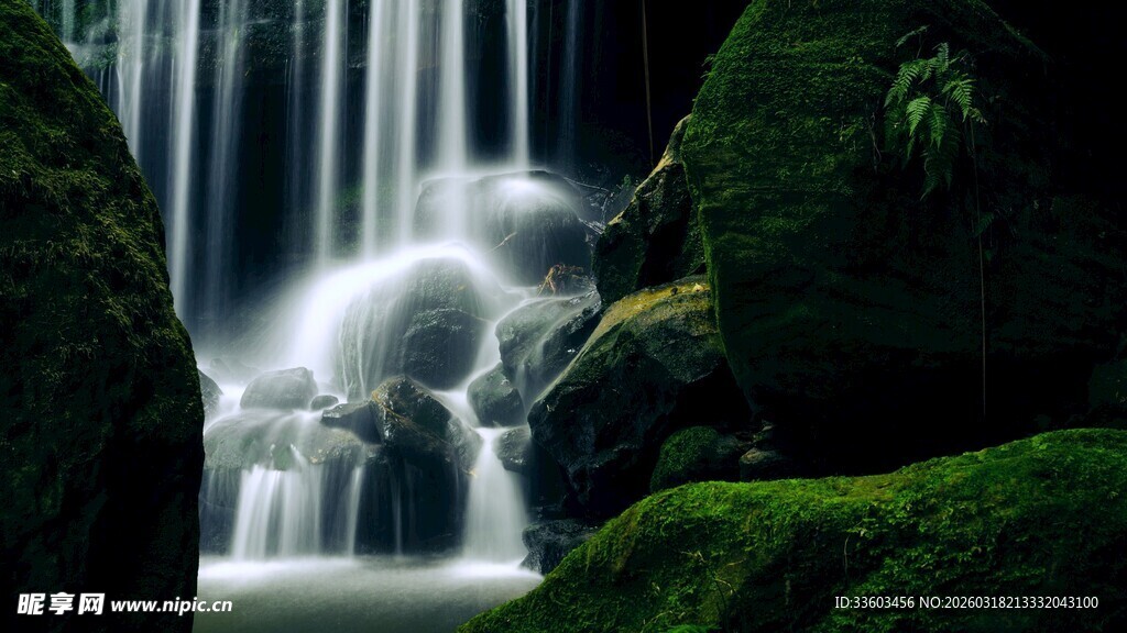 山间瀑布下的翠绿岩石