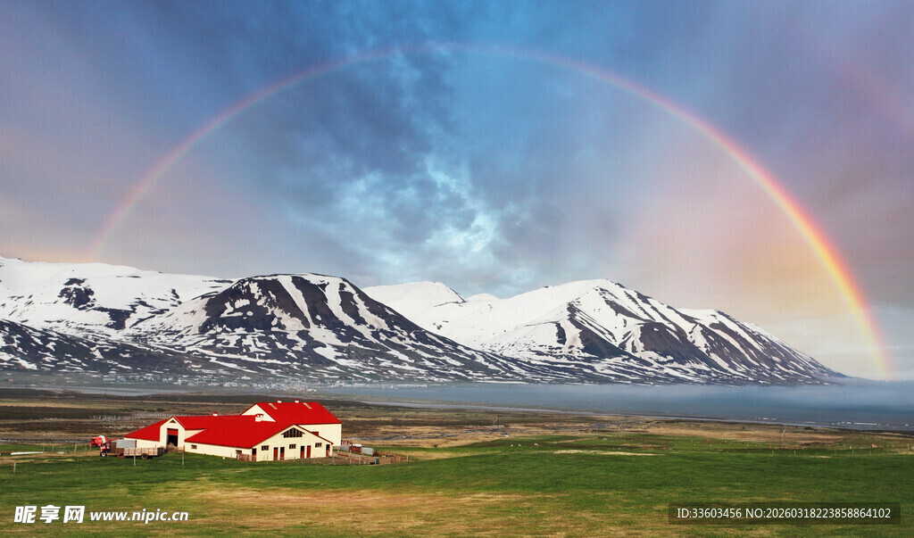 雪山下彩虹旁的红顶小屋