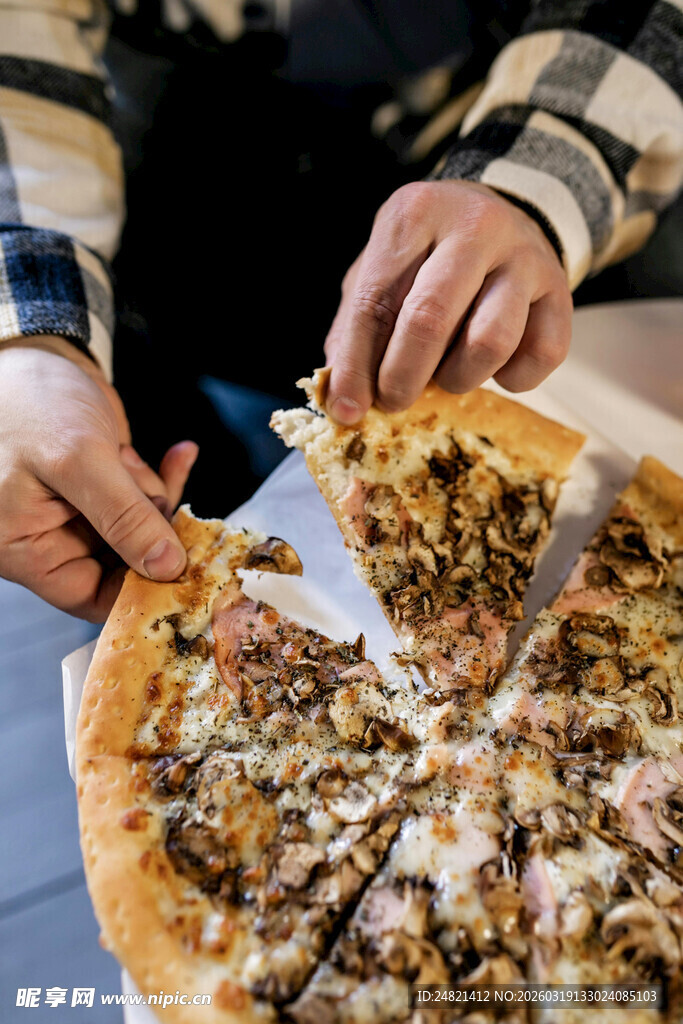 美味披萨被双手拿取品尝