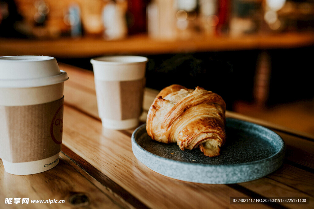 木桌上的咖啡与可颂面包