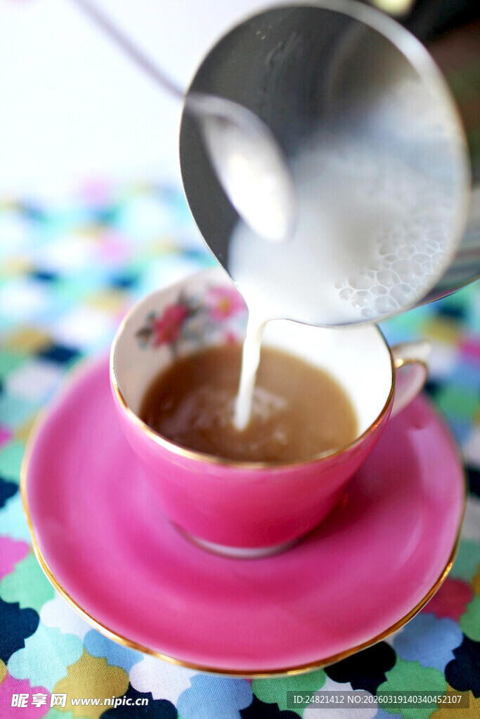 粉色杯中正倒入香醇牛奶