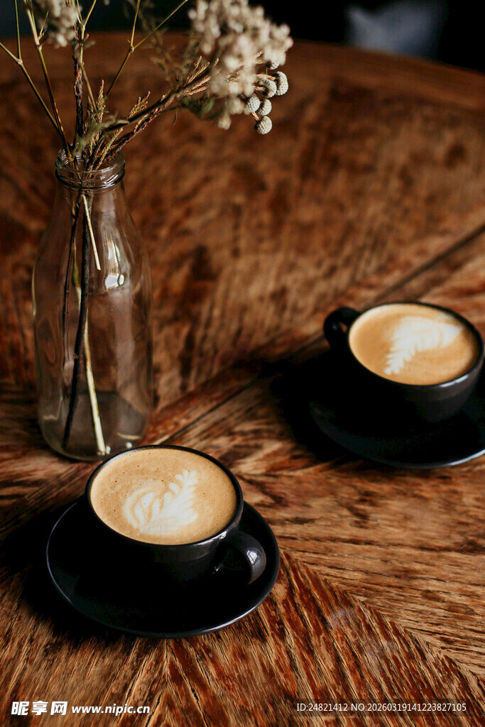 木质桌上两杯精致拉花咖啡