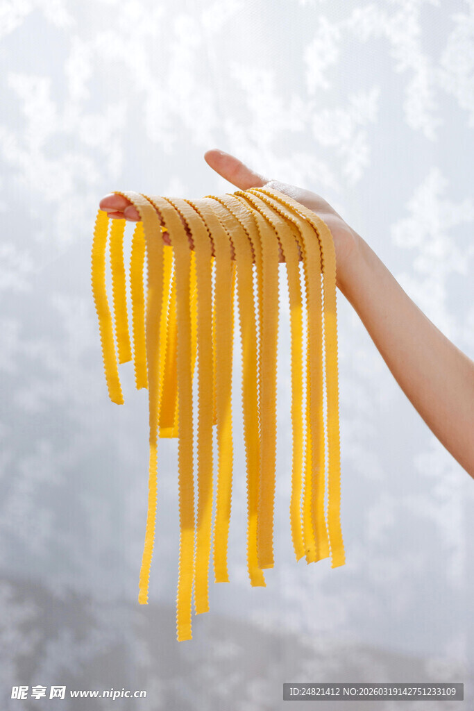 手捧新鲜黄色长条意面